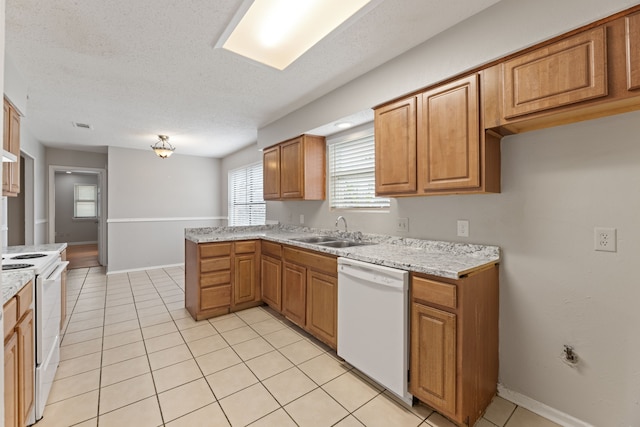 kitchen featuring white appliances, sink, a textured ceiling, and light tile patterned floors