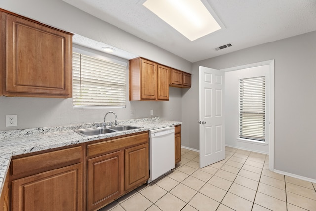 kitchen with a healthy amount of sunlight, white dishwasher, sink, and light tile patterned floors