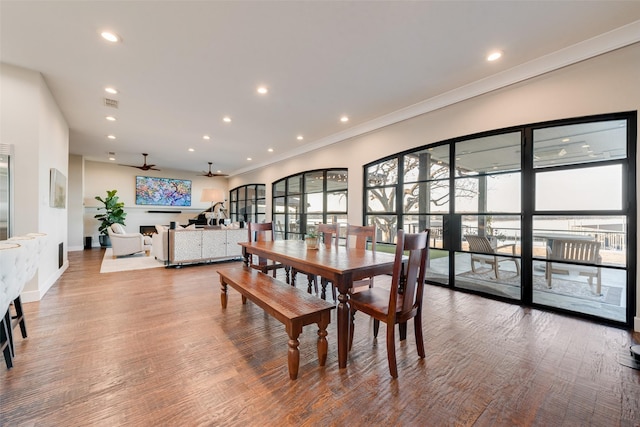 dining space with hardwood / wood-style flooring, ornamental molding, and ceiling fan