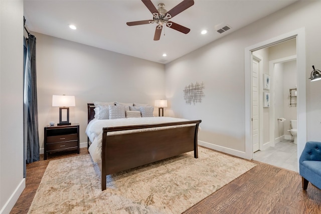 bedroom with ceiling fan, ensuite bath, and light hardwood / wood-style floors