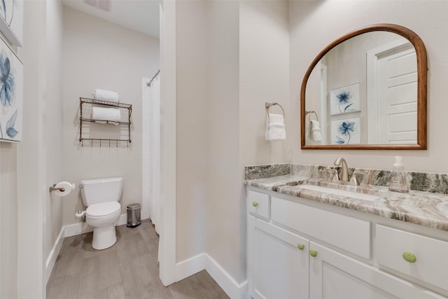 bathroom with vanity, toilet, curtained shower, and wood-type flooring