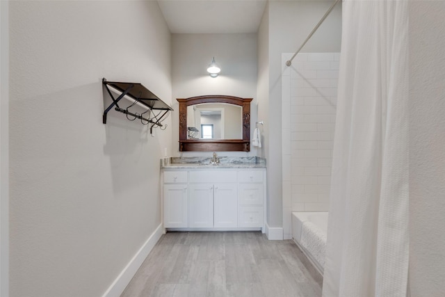 bathroom featuring wood-type flooring, shower / bathtub combination with curtain, and vanity