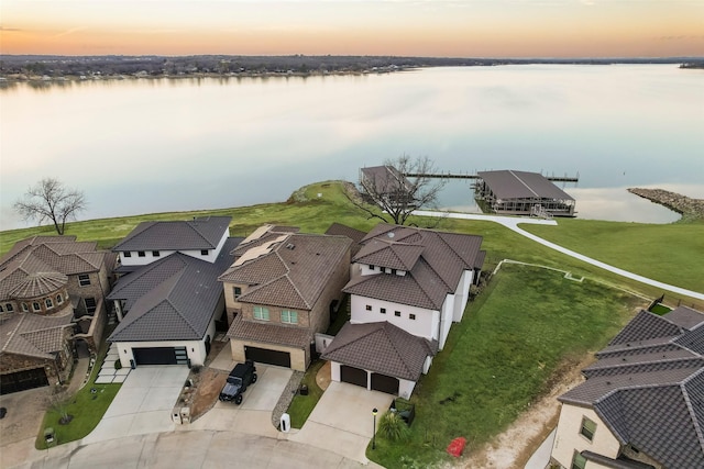 aerial view at dusk featuring a water view