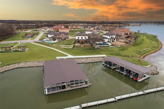 aerial view at dusk featuring a water view