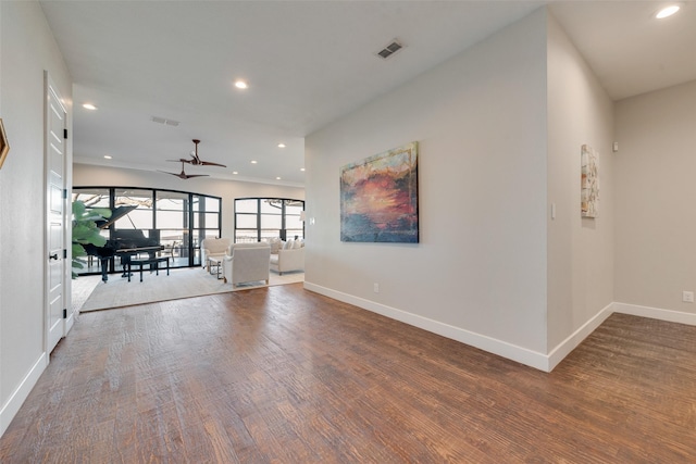 unfurnished living room with wood-type flooring and ceiling fan