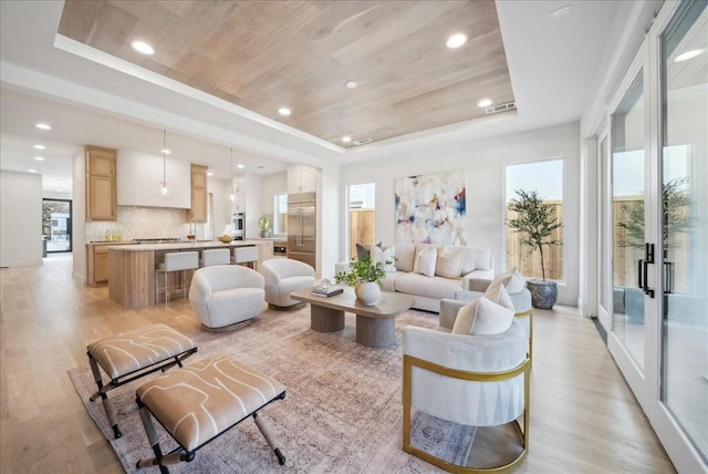 living room featuring a raised ceiling, wood ceiling, and light hardwood / wood-style flooring