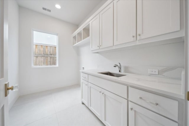 washroom with cabinets, sink, and light tile patterned floors