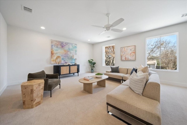 living room with light carpet, a wealth of natural light, and ceiling fan