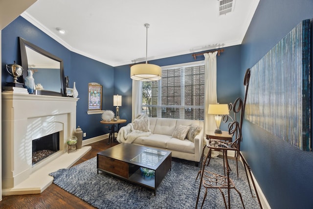 living area featuring baseboards, visible vents, a premium fireplace, wood finished floors, and crown molding