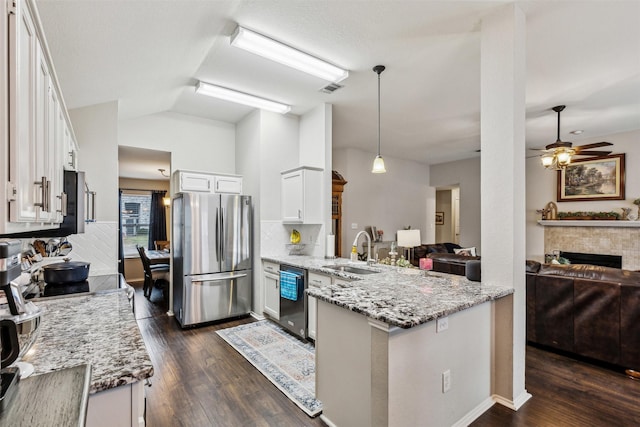 kitchen with sink, appliances with stainless steel finishes, hanging light fixtures, white cabinets, and kitchen peninsula