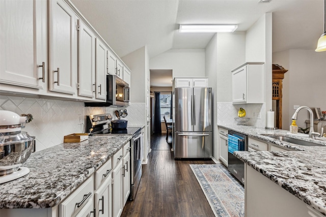 kitchen featuring hanging light fixtures, stainless steel appliances, and white cabinets