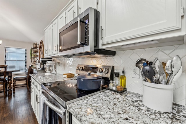 kitchen with tasteful backsplash, stainless steel appliances, light stone countertops, and white cabinets