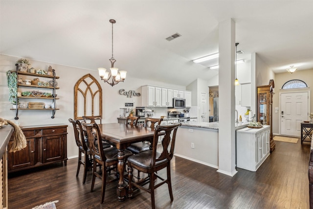 dining room featuring vaulted ceiling, dark wood-type flooring, and a notable chandelier