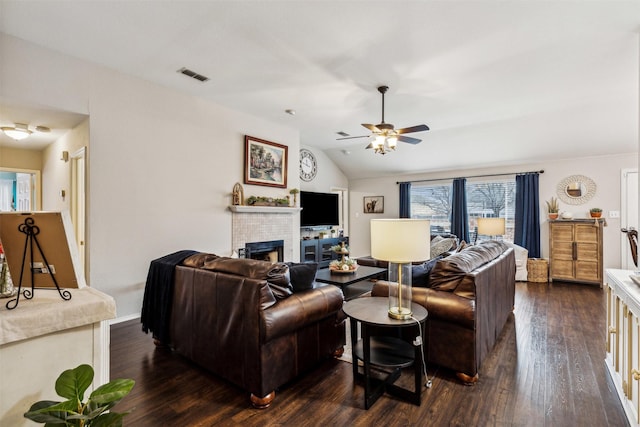 living room featuring lofted ceiling, a brick fireplace, dark hardwood / wood-style flooring, and ceiling fan