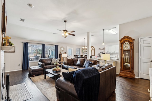 living room with dark hardwood / wood-style flooring, ceiling fan with notable chandelier, and lofted ceiling