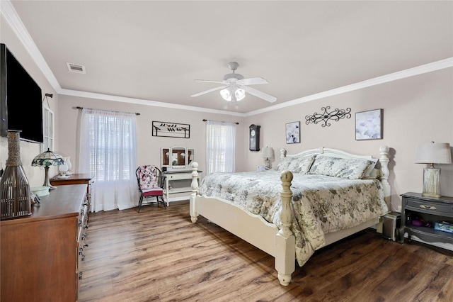 bedroom with hardwood / wood-style floors, ornamental molding, and ceiling fan