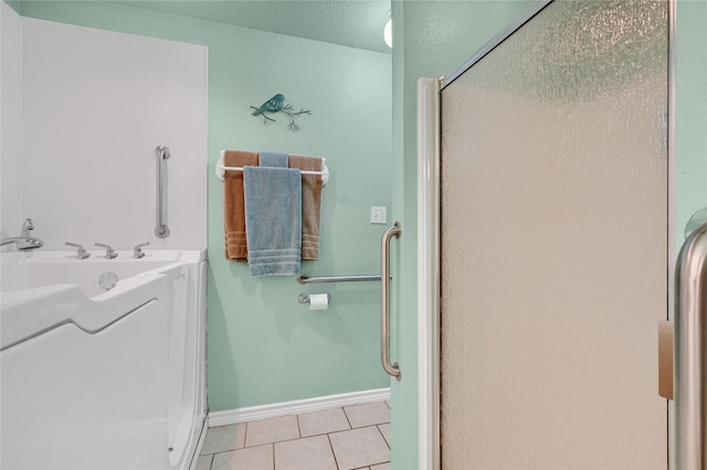 bathroom featuring a shower with door, sink, and tile patterned floors