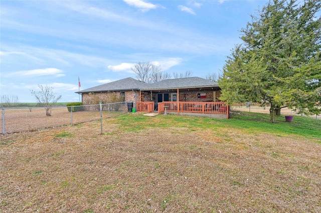 back of property with a wooden deck and a lawn