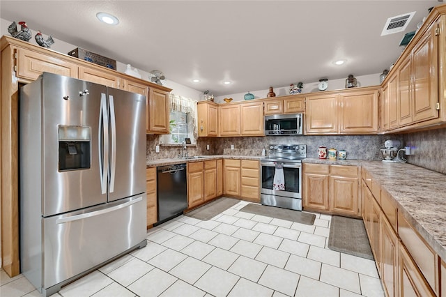 kitchen with light brown cabinetry, sink, tasteful backsplash, light stone counters, and stainless steel appliances