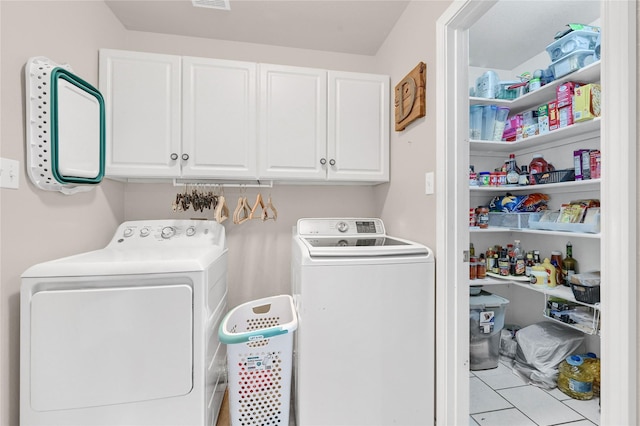 laundry room featuring cabinets, separate washer and dryer, and light tile patterned floors