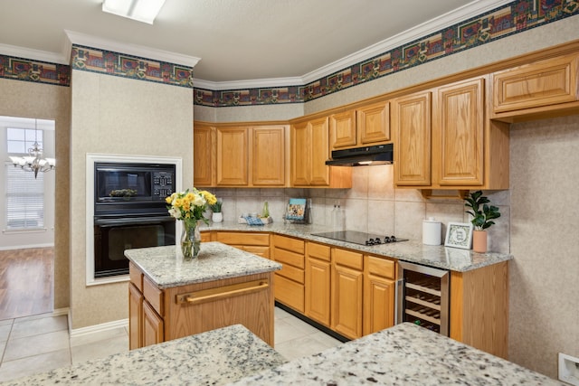 kitchen with light stone counters, ornamental molding, a kitchen island, beverage cooler, and black appliances