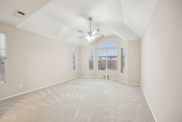 empty room with ceiling fan, light colored carpet, and vaulted ceiling