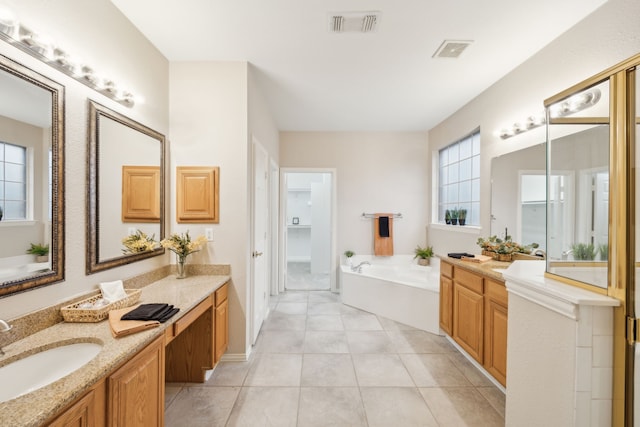 bathroom featuring tile patterned flooring, vanity, and a tub