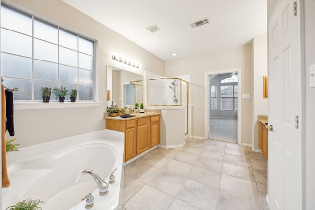 bathroom with tile patterned floors, vanity, and shower with separate bathtub