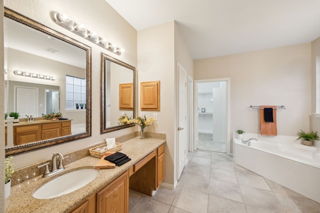 bathroom featuring tile patterned floors, vanity, and a tub