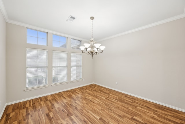 unfurnished room with hardwood / wood-style flooring, crown molding, and an inviting chandelier