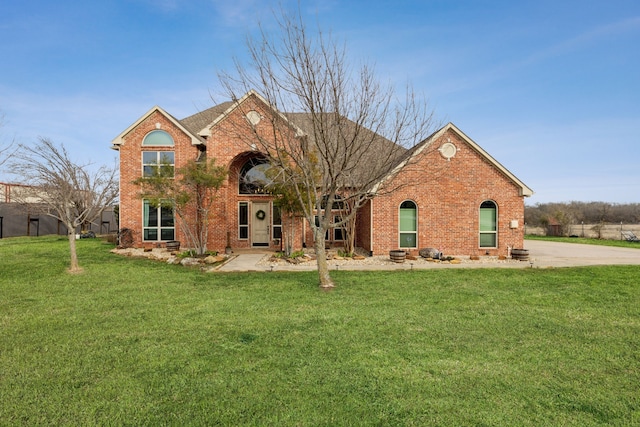 view of front facade featuring brick siding and a front yard