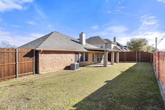 rear view of property with a yard and central AC