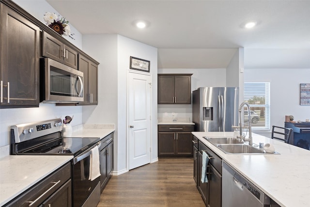 kitchen featuring dark brown cabinetry, stainless steel appliances, dark hardwood / wood-style flooring, and sink