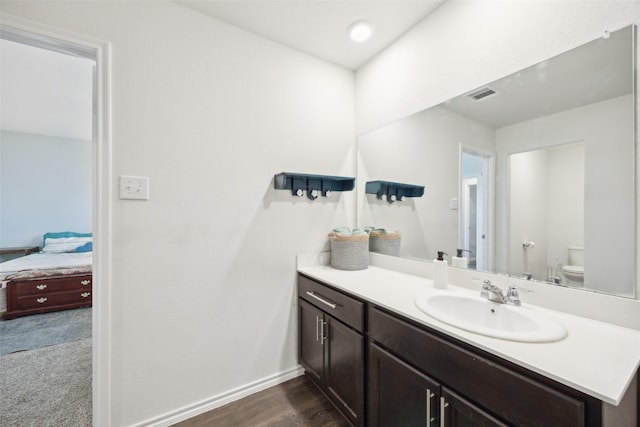 bathroom with vanity, toilet, and wood-type flooring