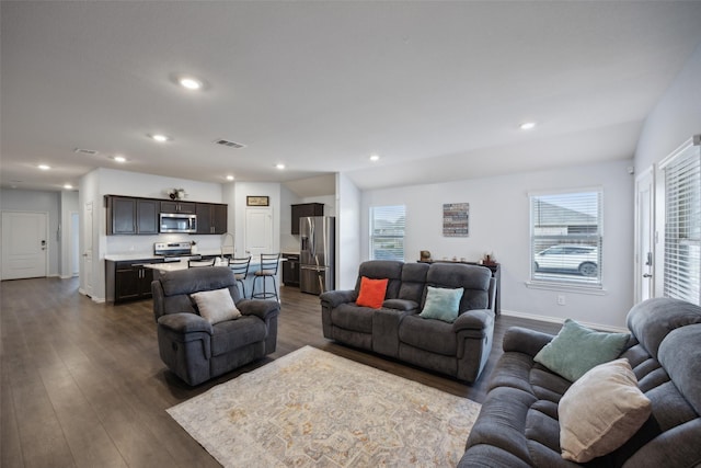 living room with lofted ceiling, dark hardwood / wood-style floors, and a wealth of natural light