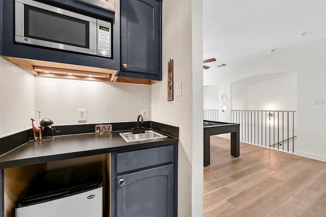 kitchen featuring blue cabinets, light hardwood / wood-style floors, and sink