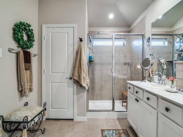 bathroom featuring vanity, plenty of natural light, lofted ceiling, and tile patterned floors