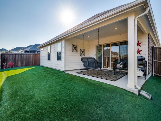 back of house with a yard and a patio