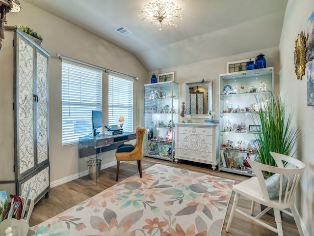 office with hardwood / wood-style flooring, lofted ceiling, and a notable chandelier