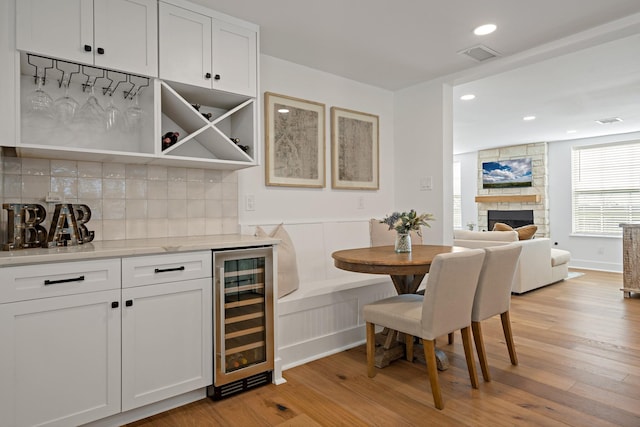209 Mary Fitch Rd, Sherman, TX 75090 - indoor dry bar featuring beverage cooler, light wood finished floors, tasteful backsplash, recessed lighting, and a fireplace