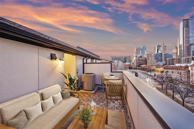 2134 Canton St, Dallas, TX 75201 - balcony at dusk featuring central air condition unit, an outdoor living space, and a city view