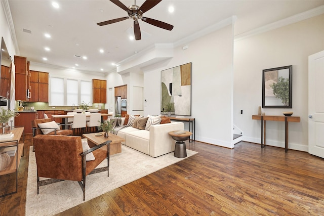 living room with crown molding, ceiling fan, and dark hardwood / wood-style floors