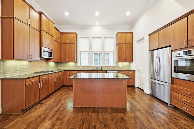 kitchen with backsplash, ornamental molding, stainless steel appliances, and a kitchen island