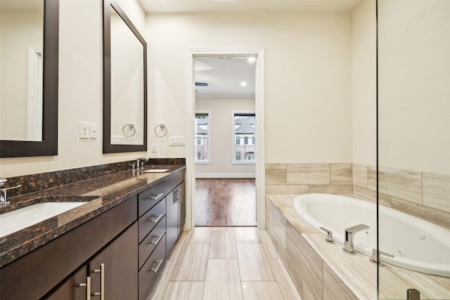 bathroom with vanity and a relaxing tiled tub