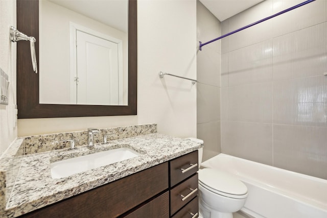 full bathroom with vanity, tiled shower / bath combo, and toilet