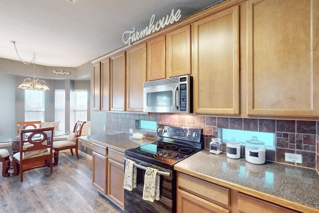 kitchen with dark wood-type flooring, an inviting chandelier, light brown cabinets, stainless steel appliances, and backsplash