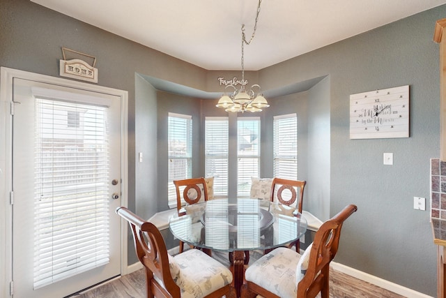 dining space featuring hardwood / wood-style floors and a notable chandelier