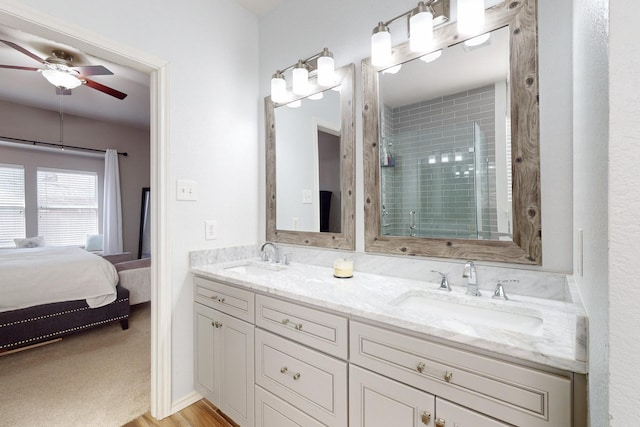 bathroom featuring walk in shower, ceiling fan, vanity, and wood-type flooring