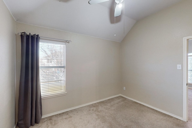 spare room with ceiling fan, lofted ceiling, and light carpet