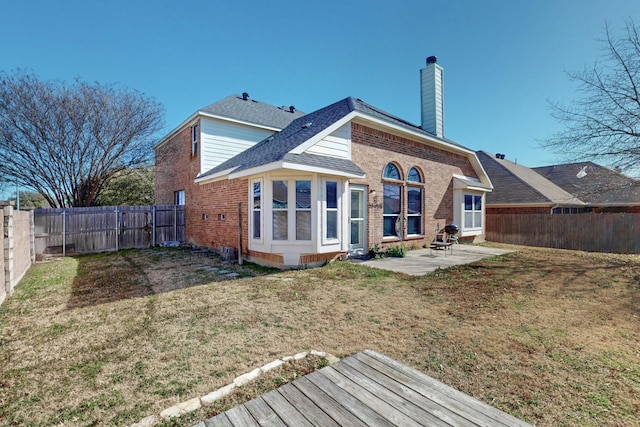 back of house with a patio and a lawn